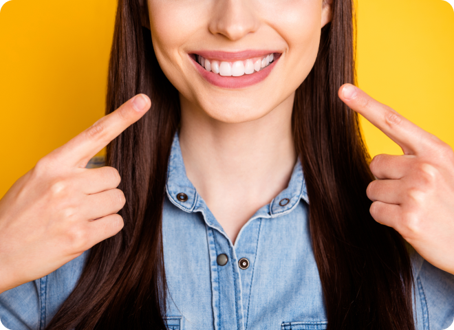 Femme souriante montrant du doigt ses bagues dentaires