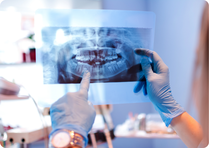 Praticien montrant une radio dentaire à l'écran au patient