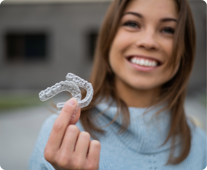 Femme souriante tenant une gouttière transparente