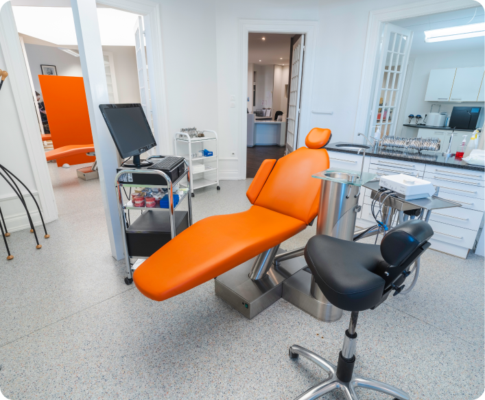 Salle de soin avec fauteuil orange et équipement dentaire